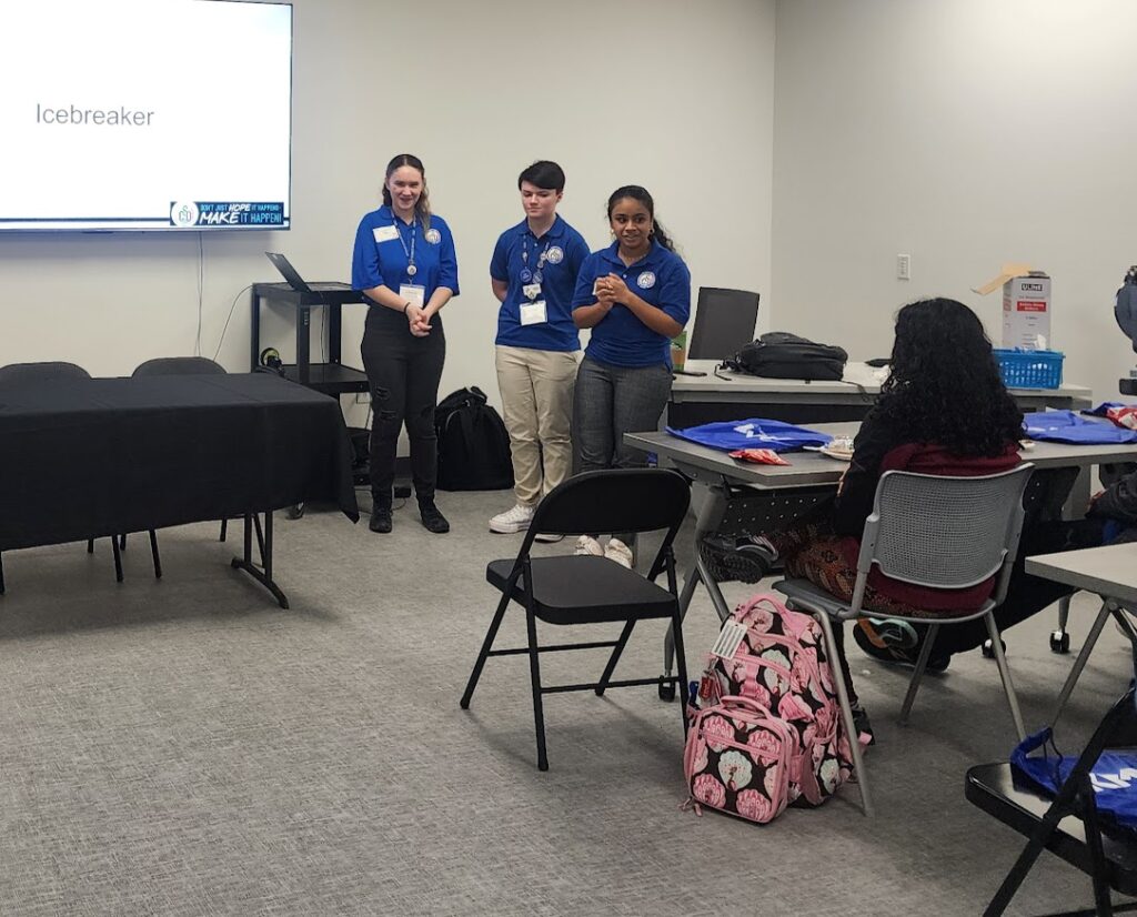 three students standing in front of a group